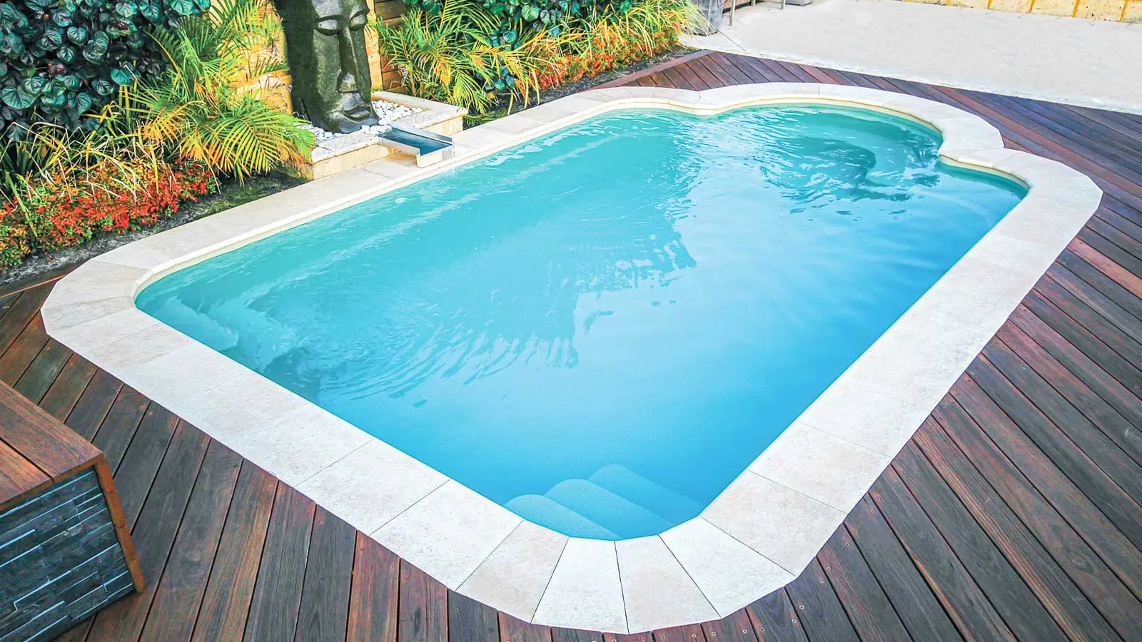 The Courtyard Roman, a fiberglass pool with individual seating carved at one end