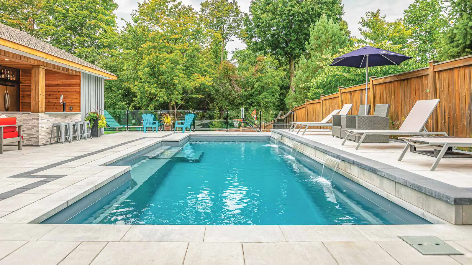 Leisure Pools Limitless rectangular fiberglass swimming pool with built-in spa and splash deck