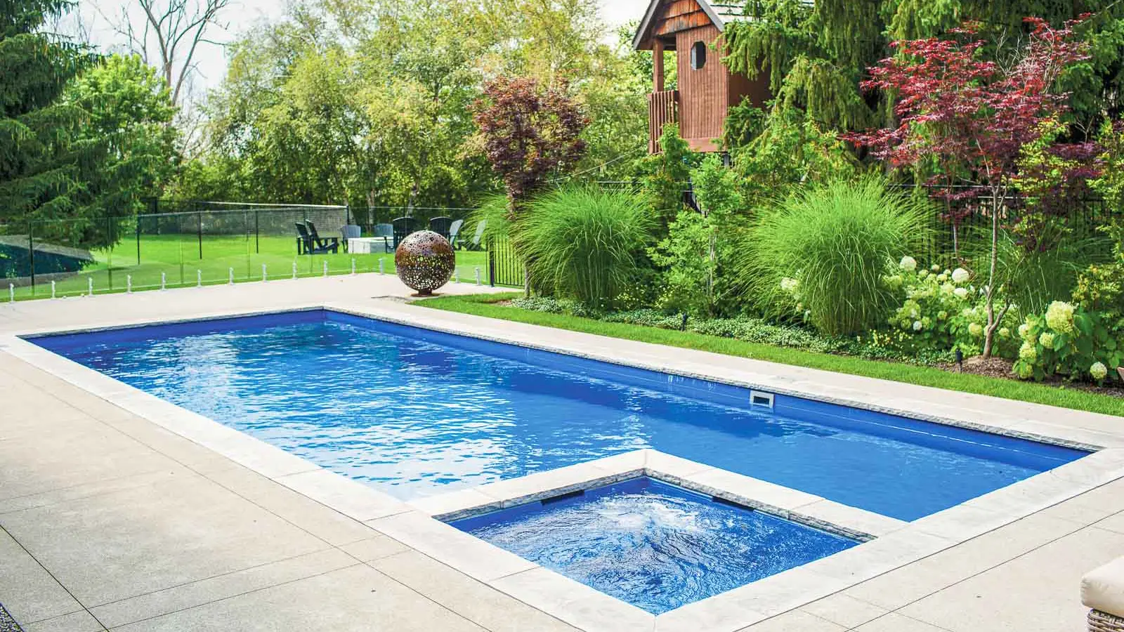 Leisure Pools Limitless rectangular fiberglass swimming pool with built-in spa and splash deck