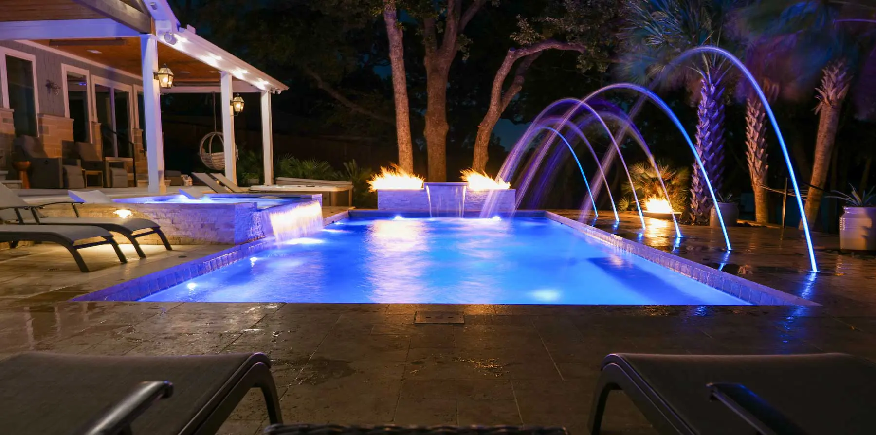 Leisure Pools Limitless rectangular fiberglass swimming pool with built-in spa and splash deck