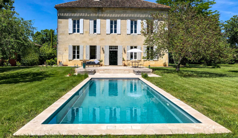 The Cube fiberglass pool in Silver Grey with classic European stone manor backdrop