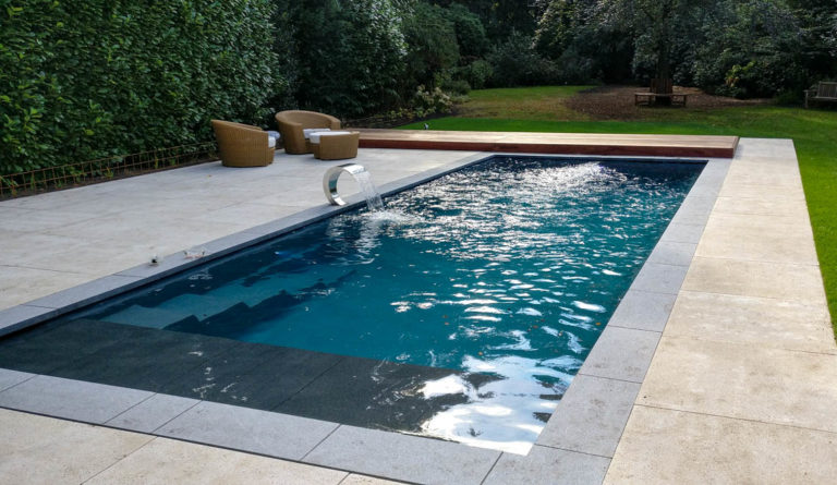 The Cube European-style fiberglass pool with contemporary stone patio surround in Graphite Grey