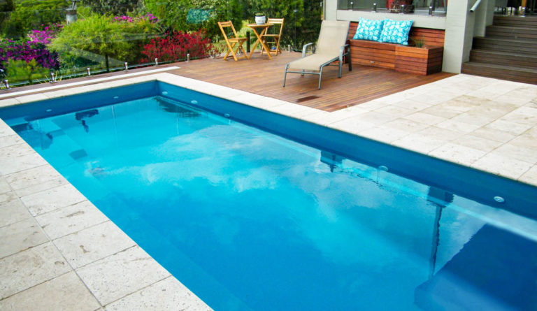 Leisure Pools Harmony 23 fiberglass pool in Crystal Blue with timber deck and poolside lounge seating