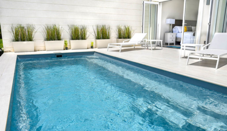Leisure Pools Harmony 26 fiberglass pool in Silver Grey with lounge chairs and modern white home