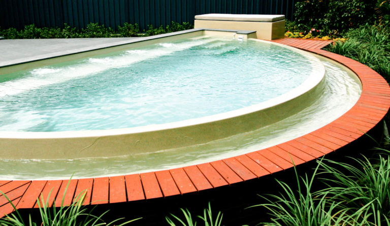 Leisure Pools Horizon fiberglass pool in Diamond Sand installed with backyard patio surround
