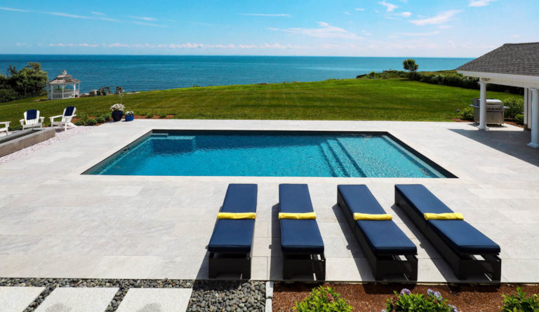 Leisure Pools Pinnacle fiberglass pool in Graphite Grey with ocean view and splash deck lounge seating