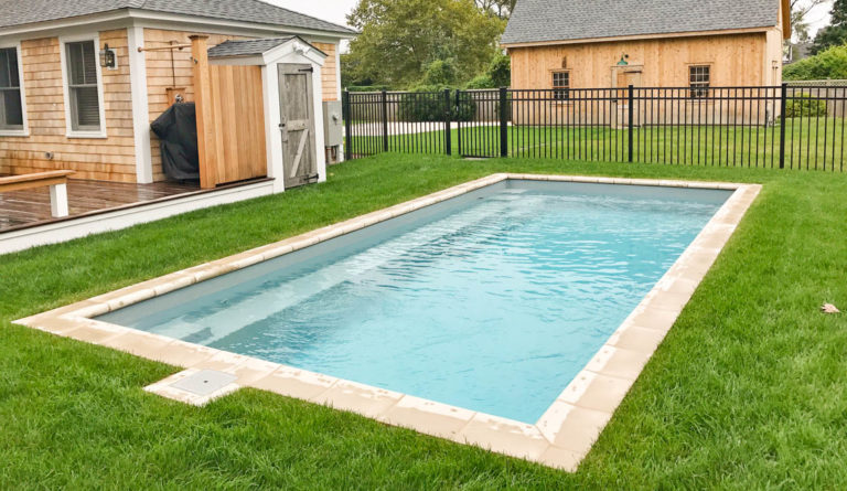 The Reflection rectangular fiberglass pool in Silver Grey with iron fence and open backyard