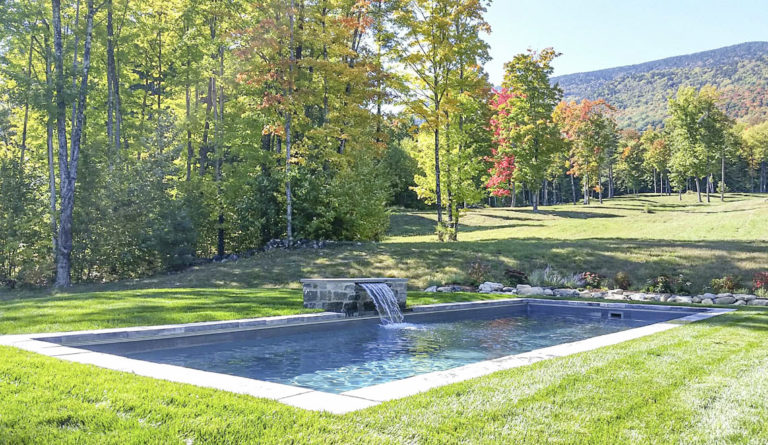 Leisure Pools Reflection fiberglass pool in Silver Grey with autumn tree backdrop and open lawn
