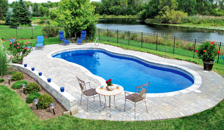 The Riviera inground fiberglass pool installed with full backyard landscaping and water view