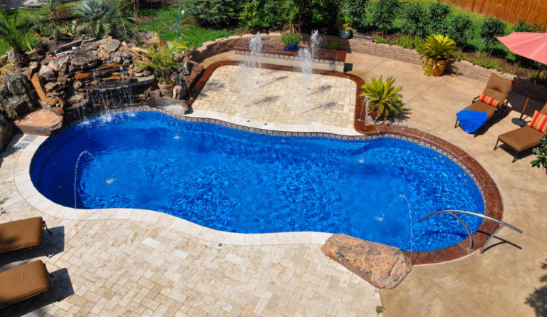 The Riviera fiberglass pool with water feature and wraparound bench seating