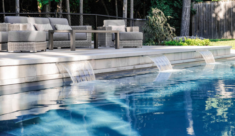 The Supreme fiberglass pool in Graphite Grey with poolside outdoor lounge seating