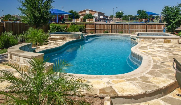 The Caribbean freeform fiberglass pool in Silver Grey installed with backyard landscaping