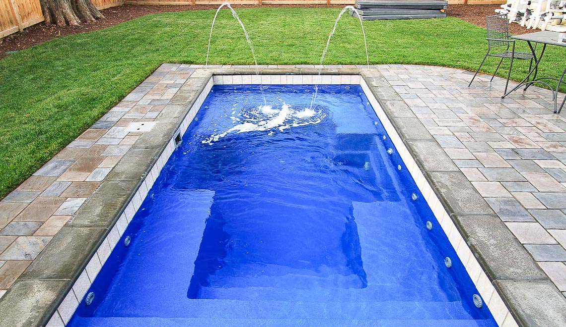 Leisure Pools Palladium Plunge fiberglass swimming pool with wrapped bench area