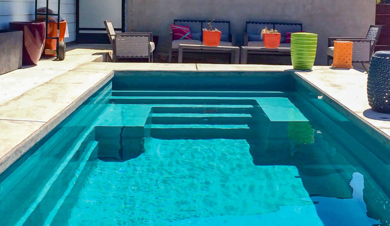 The Palladium Plunge fiberglass pool wrap around bench seat and lounge steps in Aquamarine