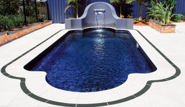 The Roman fiberglass pool in Ebony Blue with waterfall feature and deep end bench overhead view