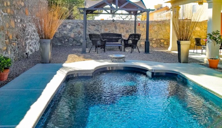 Leisure Pools Roman fiberglass pool in Ebony Blue with gazebo and desert backyard landscaping