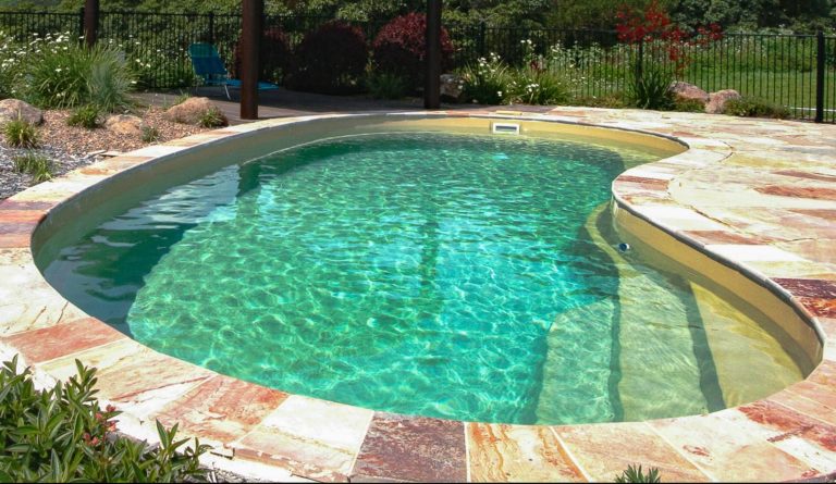The Tuscany kidney-shaped fiberglass pool shallow end steps in Diamond Sand