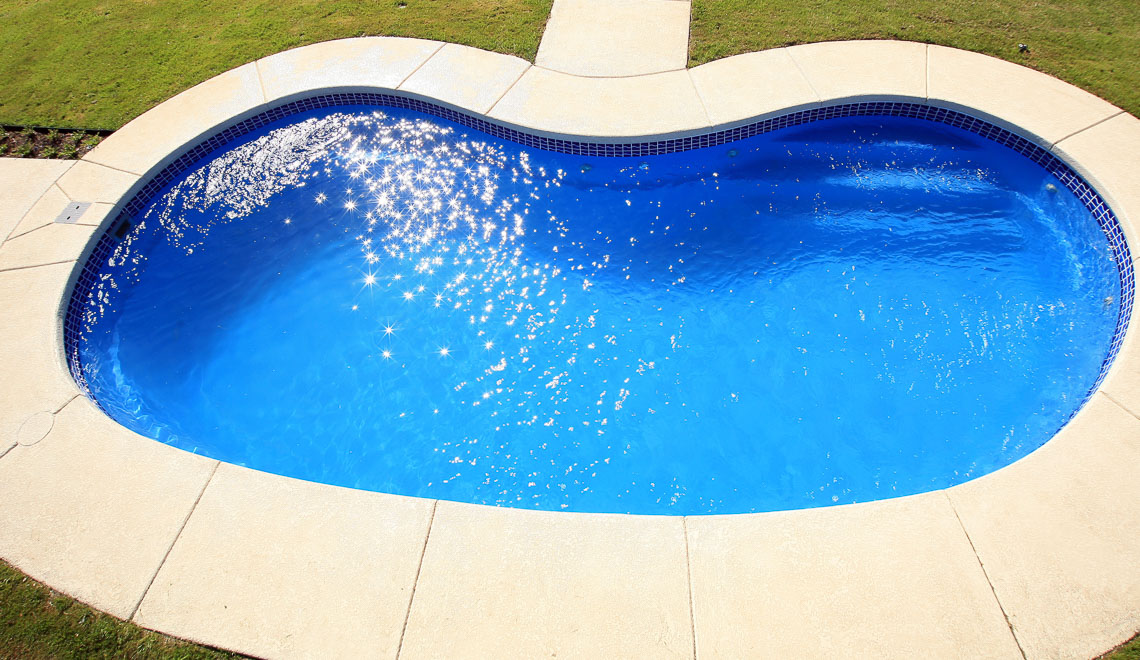 Leisure Pools Tuscany freeform fiberglass swimming pool with perimeter swimout