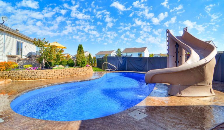 Leisure Pools Tuscany fiberglass pool in Sapphire Blue with rock water feature