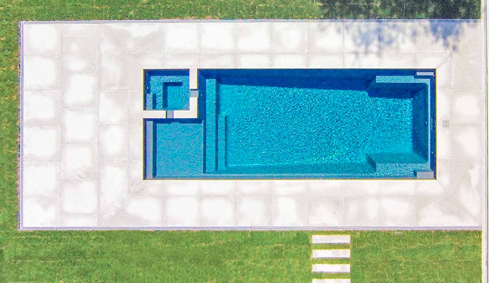 Leisure Pools Ultimate fiberglass swimming pool with built-in spa and tanning ledge