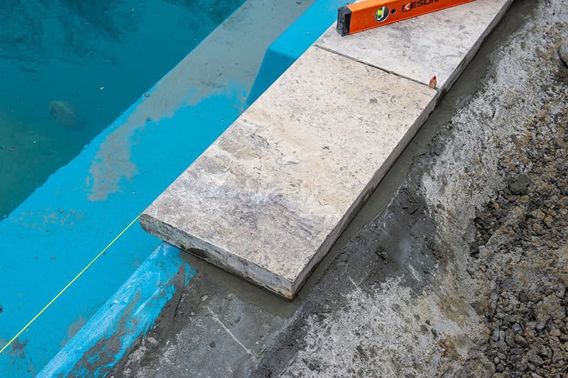 Installing coping on a Leisure Pools fiberglass swimming pool