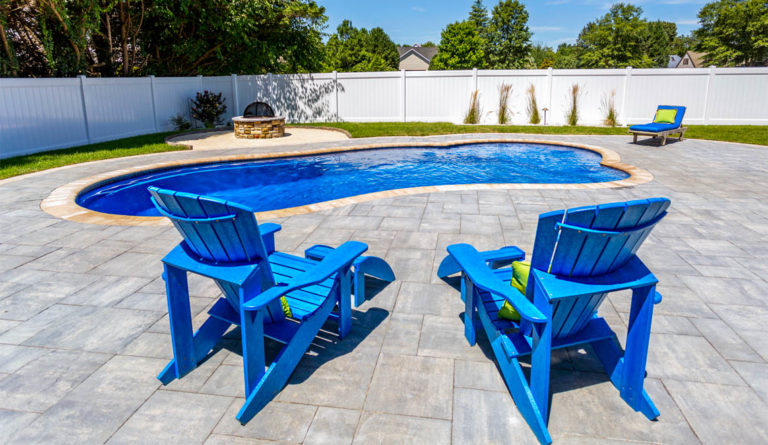 The Eclipse fiberglass pool splash deck with Adirondack seating in Sapphire Blue