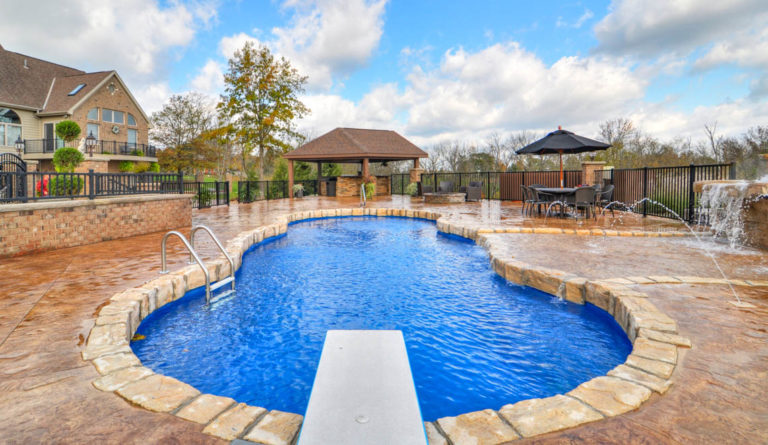 The Mediterranean fiberglass pool shallow end bench seating, diving board, and entry steps