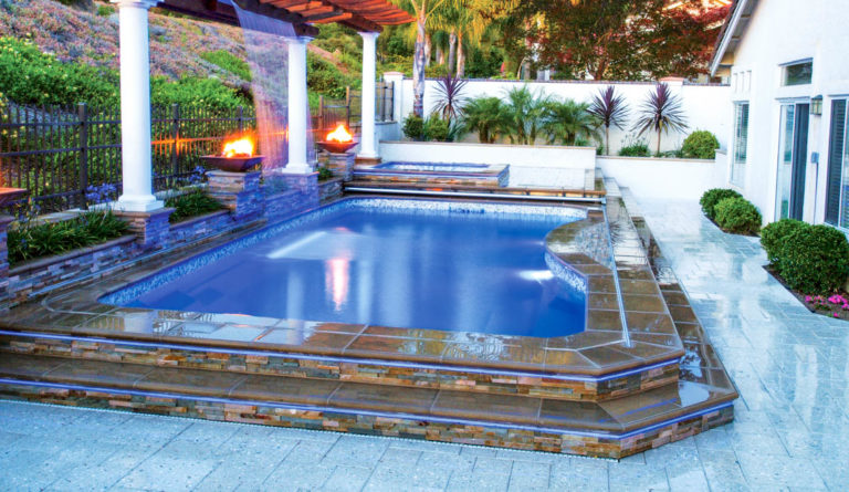 The Moroccan fiberglass pool with water feature spillover, pergola, and fire feature in Sapphire Blue
