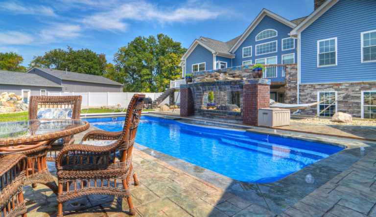 The Moroccan fiberglass pool in Sapphire Blue installed with craftsman style home backdrop
