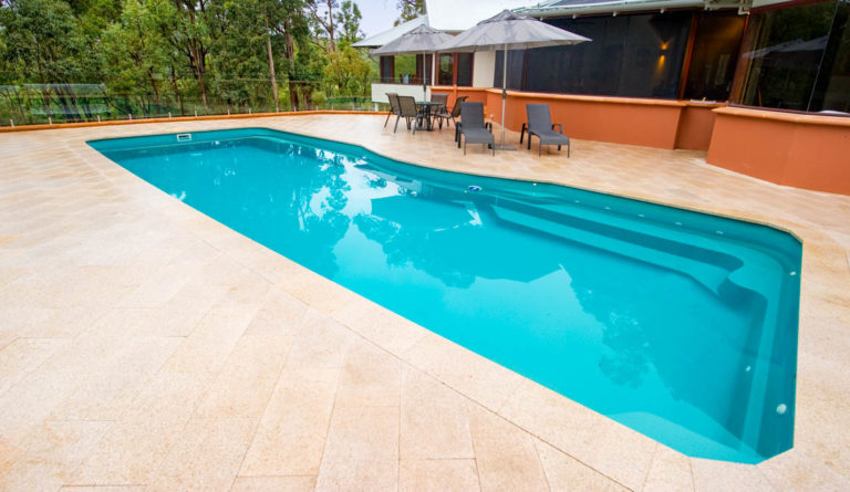 Leisure Pools Moroccan fiberglass pool in Aquamarine with entry steps and open patio surround