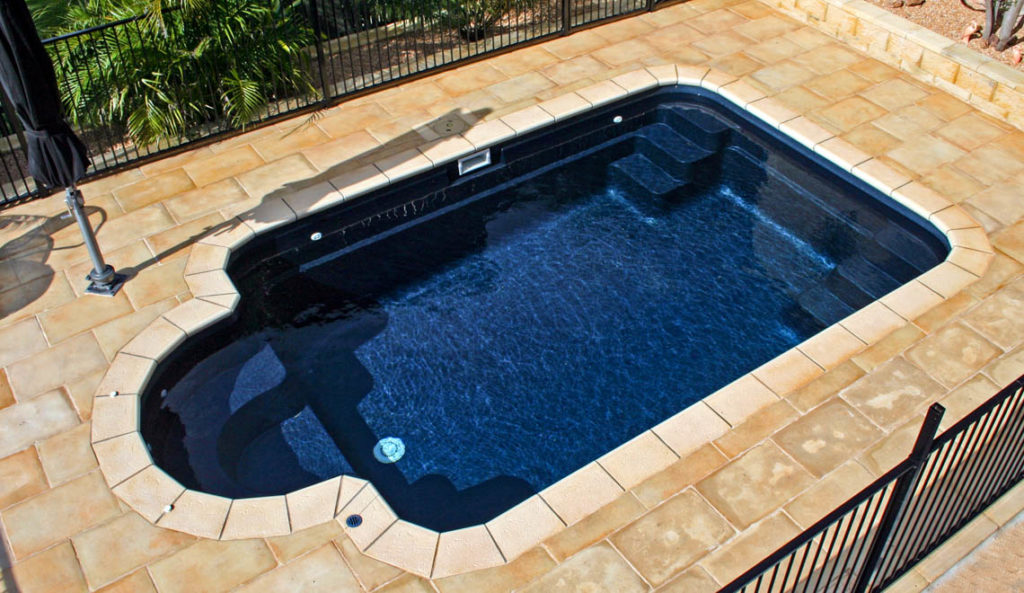 The Courtyard Roman fiberglass pool in Ebony Blue overhead view with deep end bench
