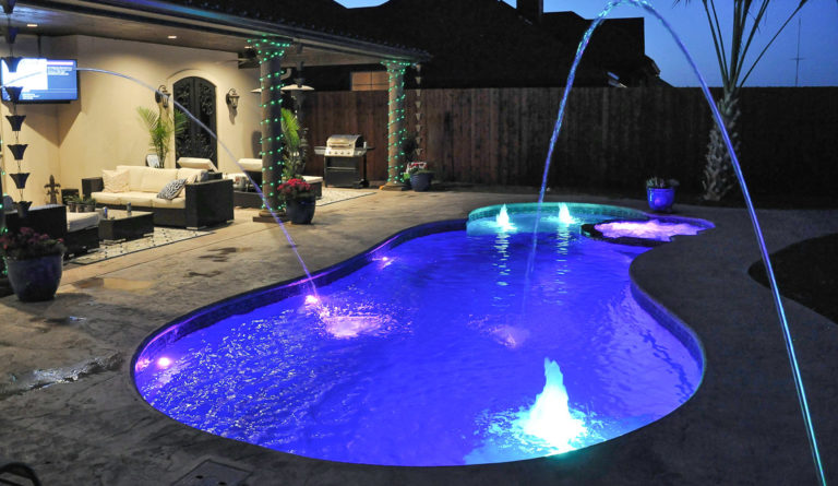 The Allure 30 freeform fiberglass pool full backyard installation n-ground water sprayers and underwater lighting
