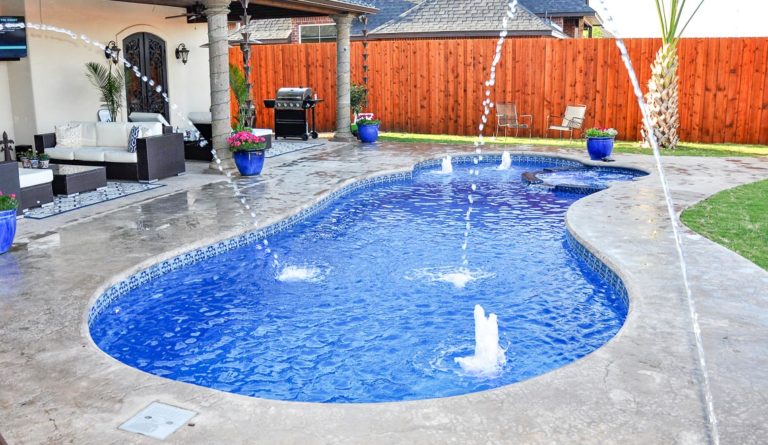 Leisure Pools Allure large freeform swimming pool with water sprayers and spacious splash deck