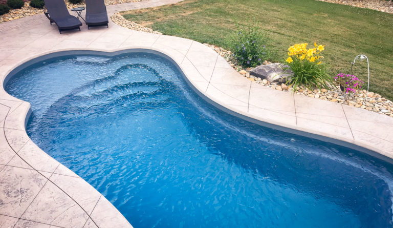 The Eclipse fiberglass pool generous entry steps and curved spa nook detail in Graphite Grey