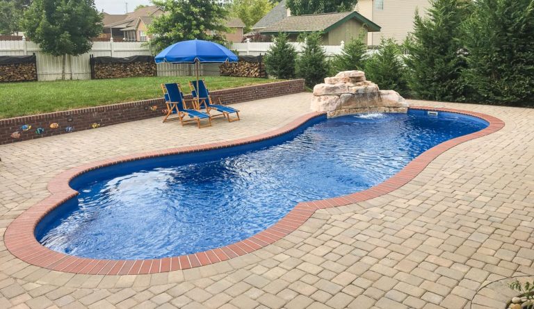 The Eclipse fiberglass pool in Sapphire Blue with decorative terracotta paver surround