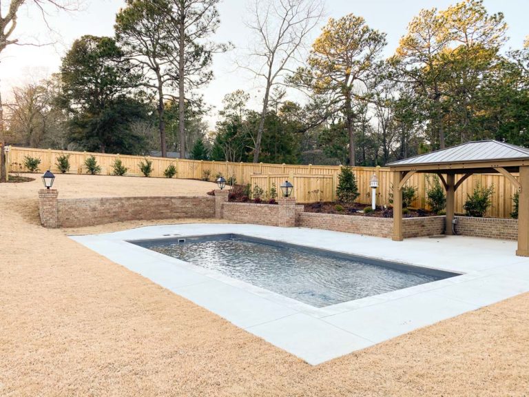 The Summit 30 fiberglass pool in Graphite Grey with elevated retaining wall and open winter landscape