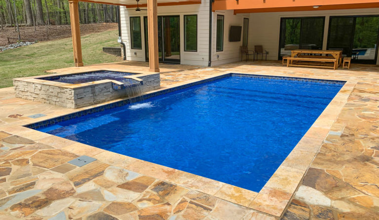 The Summit fiberglass pool in Sapphire Blue with decorative mosaic tile paver surround
