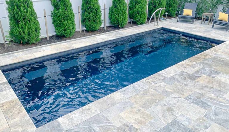 The Harmony 23 inground fiberglass pool in Ebony Blue with open backyard installation