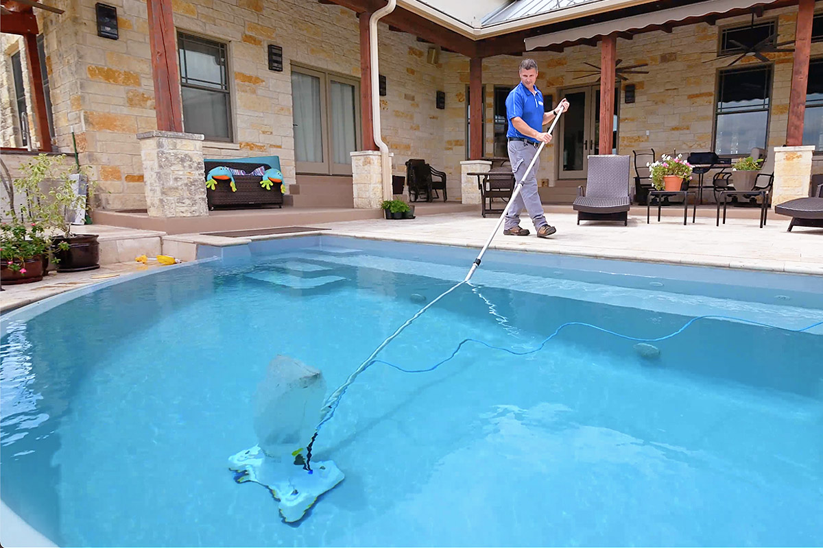 Swimming pool equipment being used to clean a pool