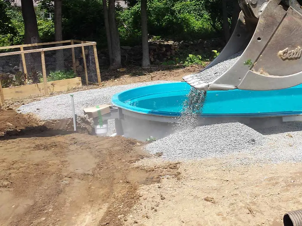 a fiberglass pool builder is backfilling a Leisure Pools inground swimming pool