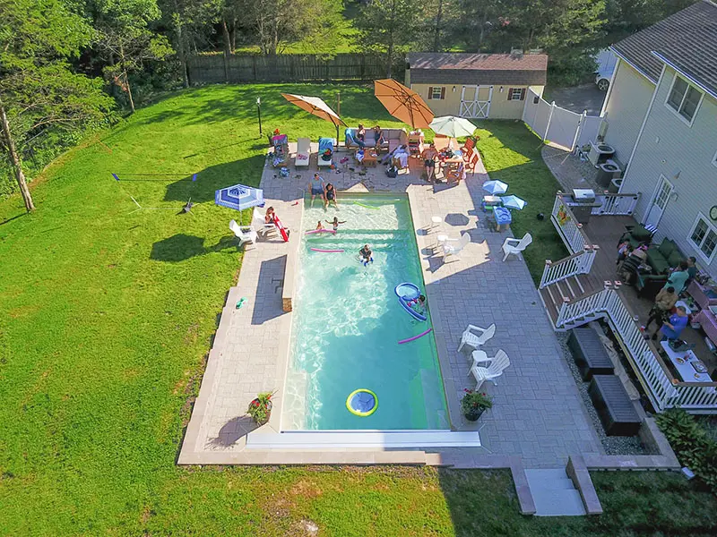 Leisure Pools Pinnacle fiberglass inground swimming pool features a sun shelf area