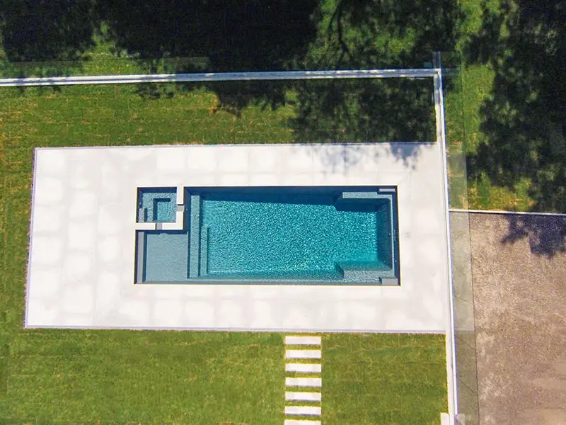 Leisure Pools Ultimate fiberglass inground swimming pool features a sun shelf area