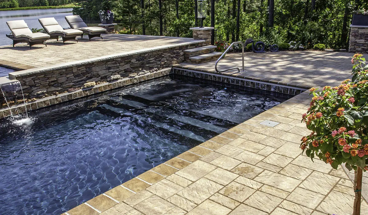 The Leisure Pools Pinnacle fiberglass unground swimming pool features a large sun shelf area