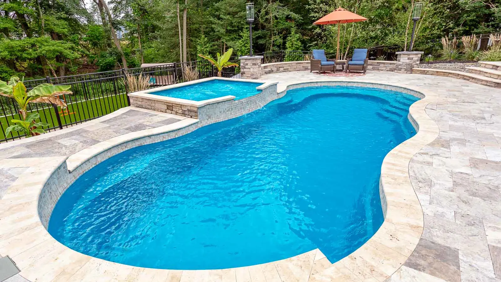 The Riviera, a freeform fiberglass pool with a wraparound entry step/ seating area and seating in the deep end