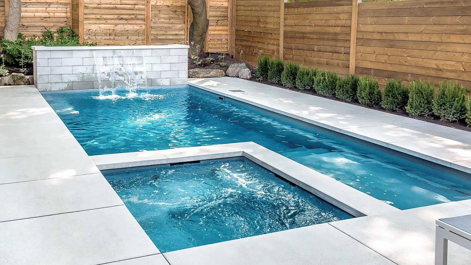 Leisure Pools Limitless rectangular fiberglass swimming pool with built-in spa and splash deck