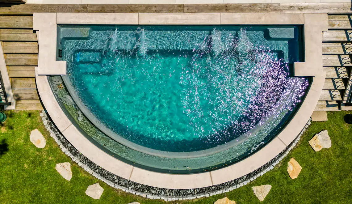 Leisure Pools Horizon composite fiberglass swimming pool with an infinity edge in Graphite Grey