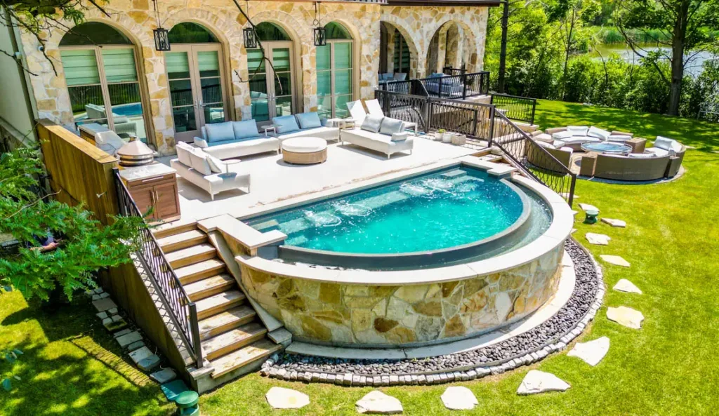 Leisure Pools Horizon fiberglass pool in Graphite Grey with vanishing edge and estate backyard