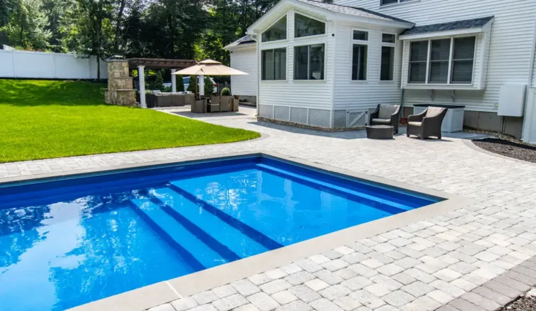 The Pinnacle fiberglass pool with full width entry step and sunroom home backdrop