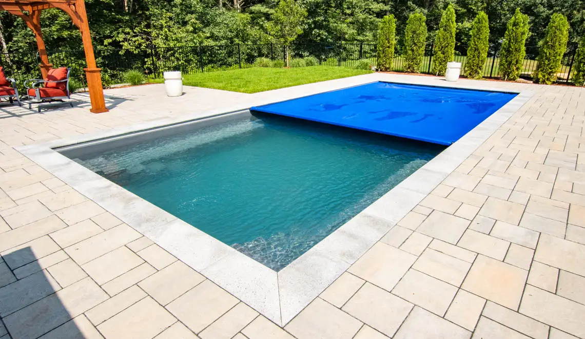 Leisure Pools Supreme inground fiberglass swimming pool with deep end swimout and bench seats in Graphite Grey