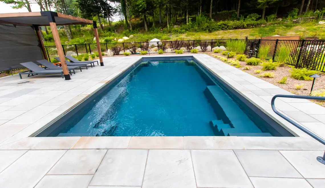Leisure Pools Supreme composite fiberglass swimming pool with deep end swimout and bench seats in Graphite Grey